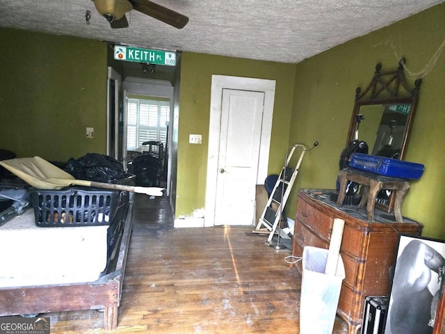 interior space featuring a textured ceiling, ceiling fan, and dark wood-type flooring