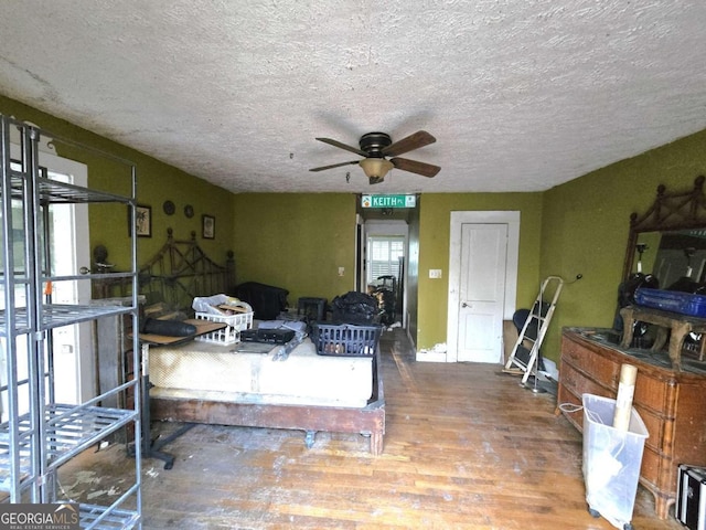 interior space featuring ceiling fan, hardwood / wood-style floors, and a textured ceiling