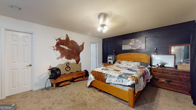 bedroom with carpet flooring, wooden walls, ceiling fan, and a textured ceiling