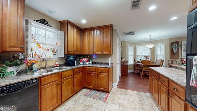 kitchen featuring light tile patterned floors, black dishwasher, decorative light fixtures, and sink