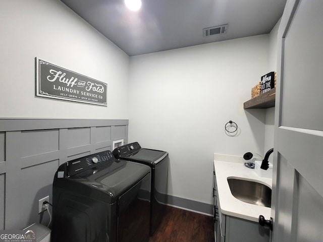 laundry room with cabinets, dark hardwood / wood-style flooring, independent washer and dryer, and sink