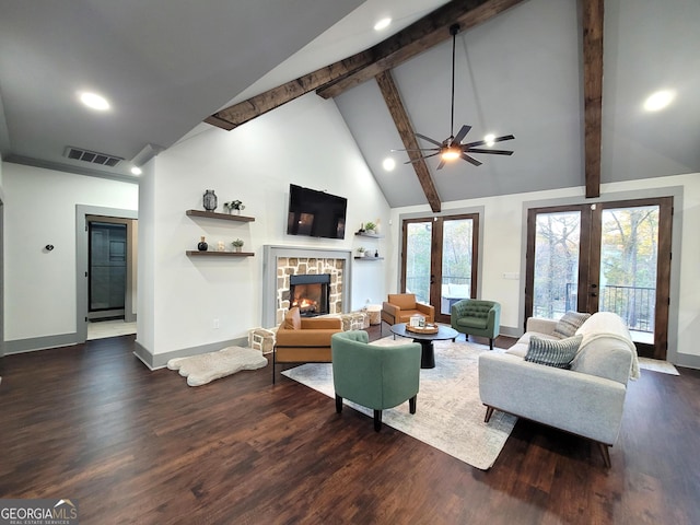 living room featuring french doors, ceiling fan, beamed ceiling, a fireplace, and dark hardwood / wood-style floors