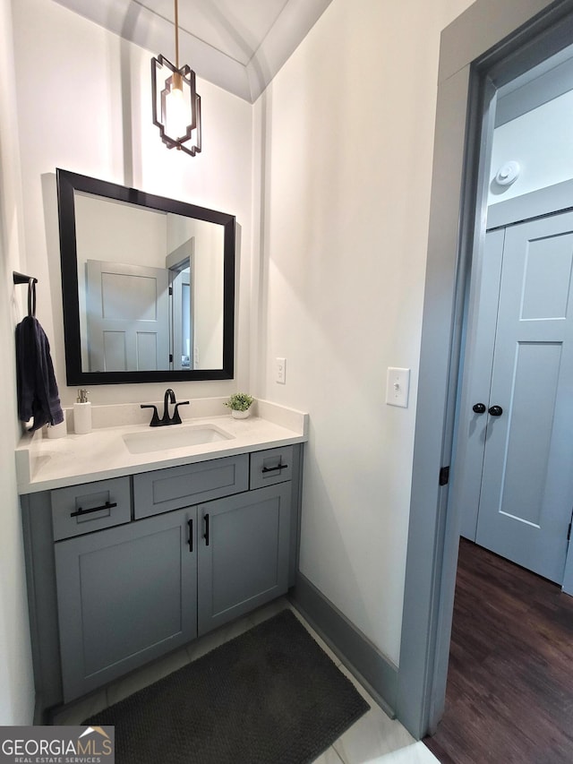 bathroom with hardwood / wood-style floors, vanity, and an inviting chandelier