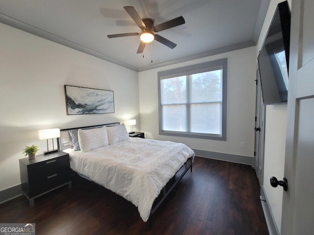 bedroom with dark wood-type flooring, ceiling fan, and crown molding