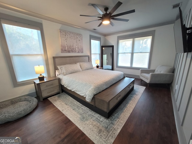 bedroom featuring ceiling fan, ornamental molding, and multiple windows