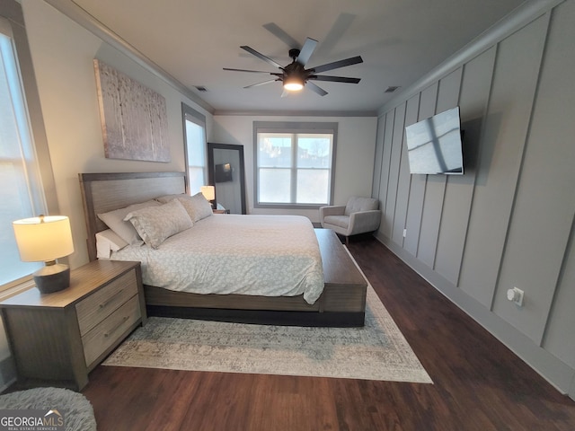 bedroom with dark hardwood / wood-style floors, ceiling fan, and crown molding