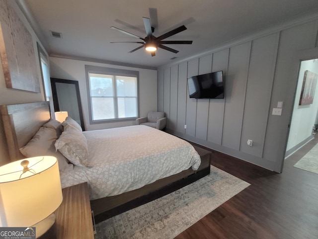 bedroom featuring dark wood-type flooring, ceiling fan, and ornamental molding