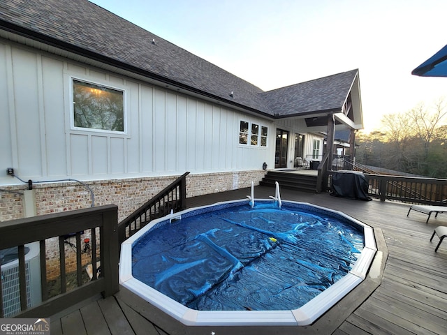 pool at dusk with central AC and a deck