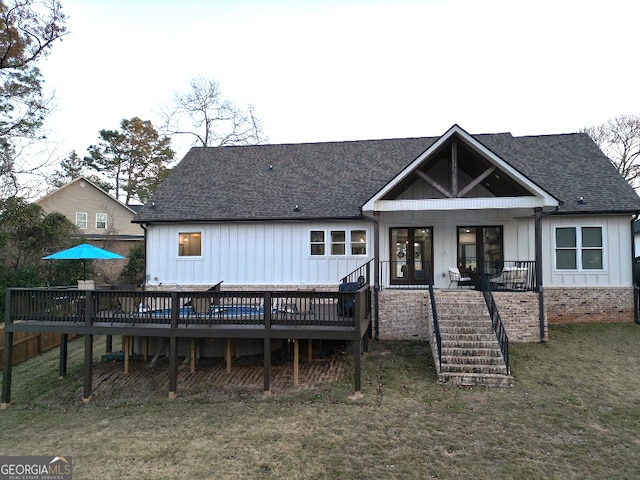 rear view of house featuring a lawn and a wooden deck