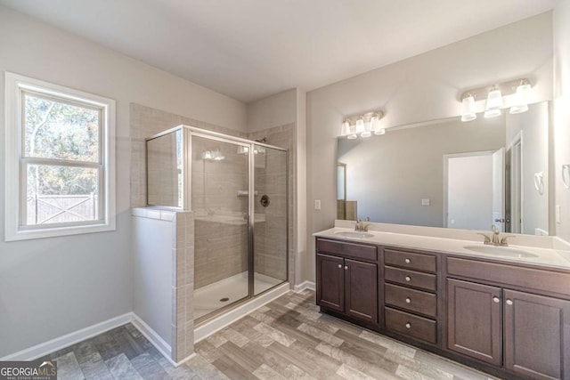 bathroom with a shower with door, vanity, and hardwood / wood-style floors