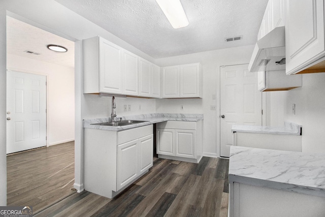 kitchen featuring white cabinetry, sink, dark hardwood / wood-style flooring, and a textured ceiling