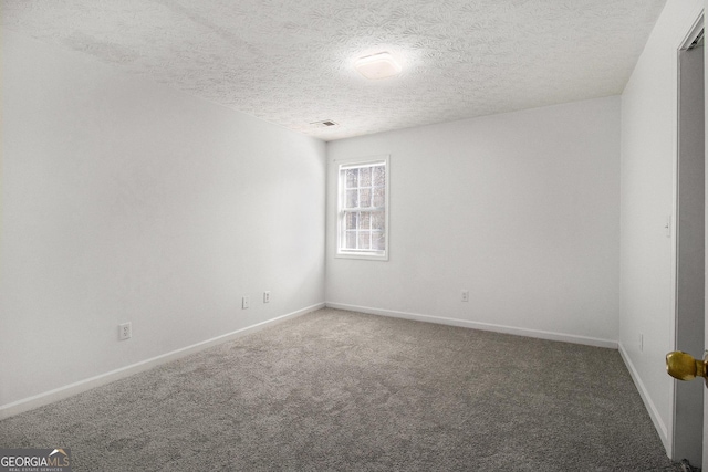 carpeted empty room with a textured ceiling