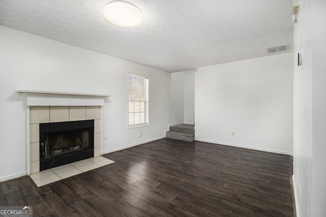 unfurnished living room featuring hardwood / wood-style flooring, a fireplace, and a textured ceiling