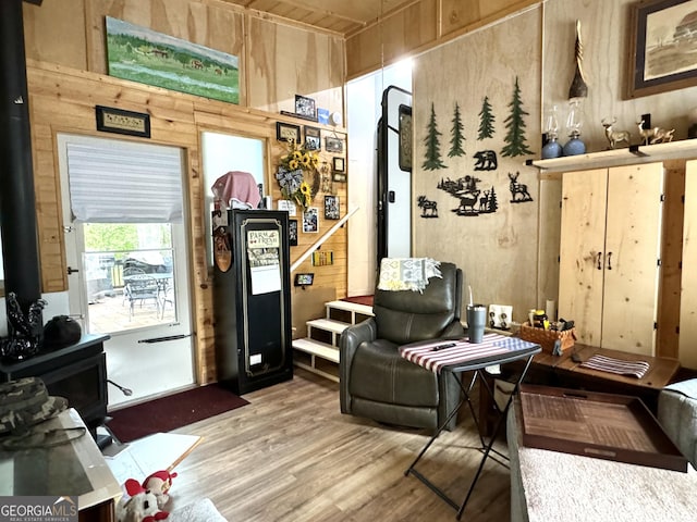 sitting room with hardwood / wood-style floors and wooden walls