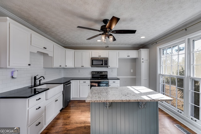 kitchen with white cabinetry, dark hardwood / wood-style floors, backsplash, a textured ceiling, and appliances with stainless steel finishes