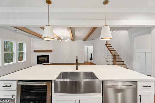 kitchen featuring wine cooler, sink, beamed ceiling, and hanging light fixtures