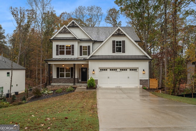 craftsman house with a front lawn, covered porch, and a garage