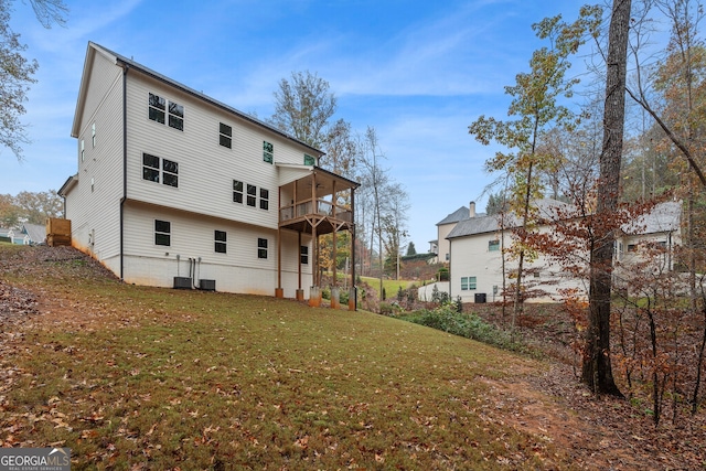 rear view of property featuring a lawn and a balcony