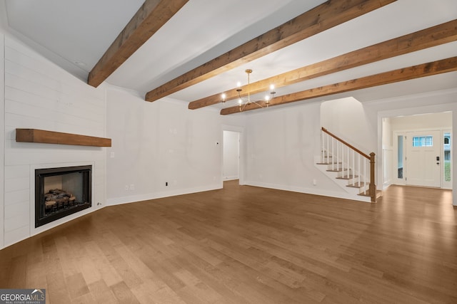 unfurnished living room featuring hardwood / wood-style floors and a large fireplace