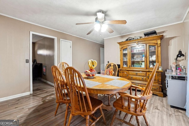 dining room with wood-type flooring, ceiling fan, and crown molding