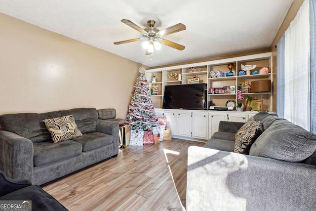 living room with ceiling fan and light wood-type flooring