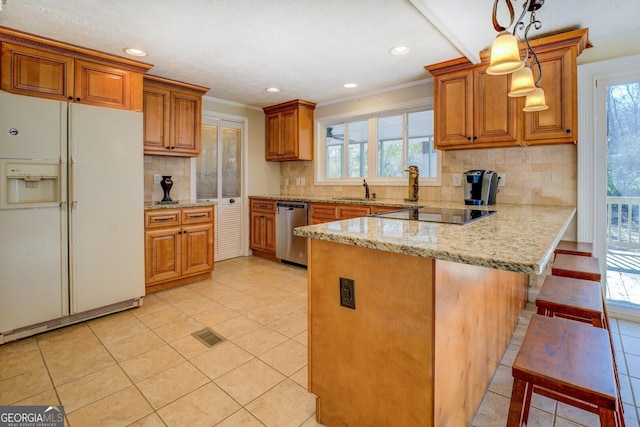 kitchen featuring white fridge with ice dispenser, stainless steel dishwasher, kitchen peninsula, pendant lighting, and a breakfast bar area