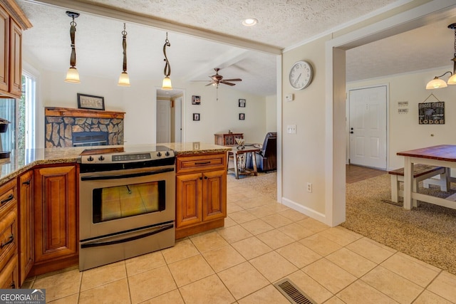 kitchen with stainless steel range with electric stovetop, ceiling fan, a textured ceiling, decorative light fixtures, and light colored carpet