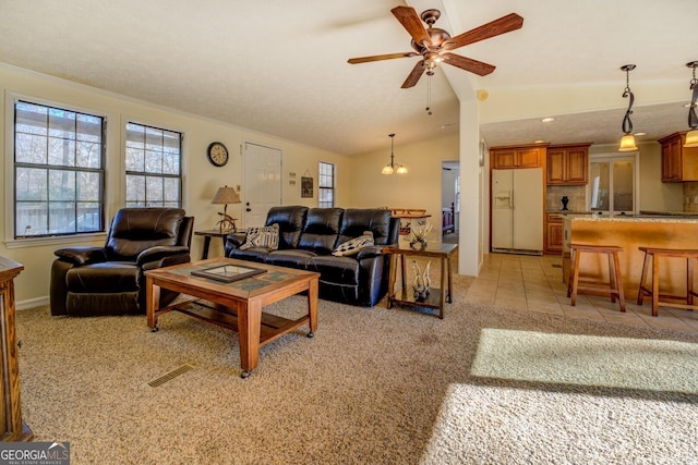 tiled living room with a textured ceiling, ceiling fan with notable chandelier, lofted ceiling, and ornamental molding