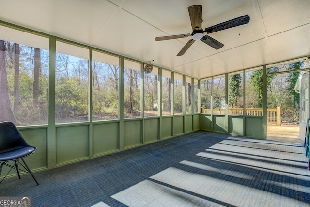 unfurnished sunroom featuring ceiling fan