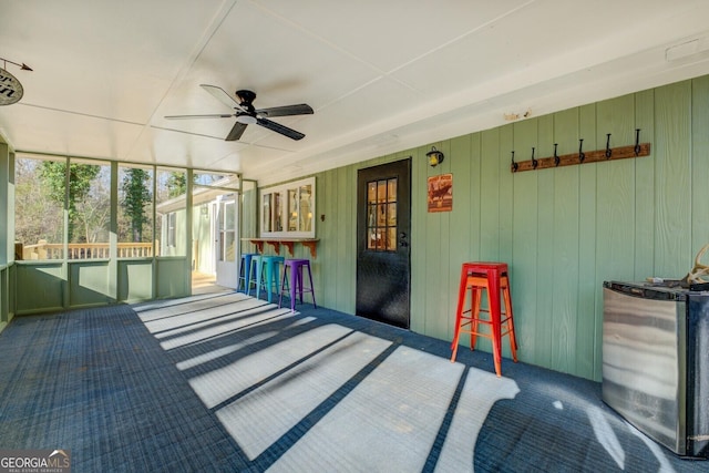 unfurnished sunroom with ceiling fan