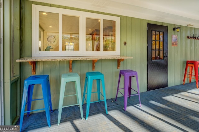 bar with carpet flooring and wood walls