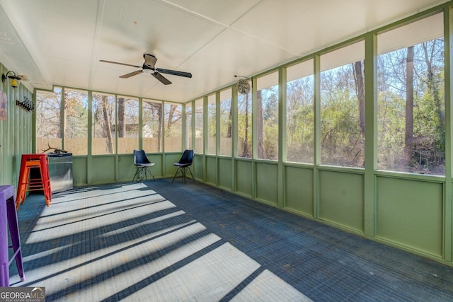 unfurnished sunroom with ceiling fan