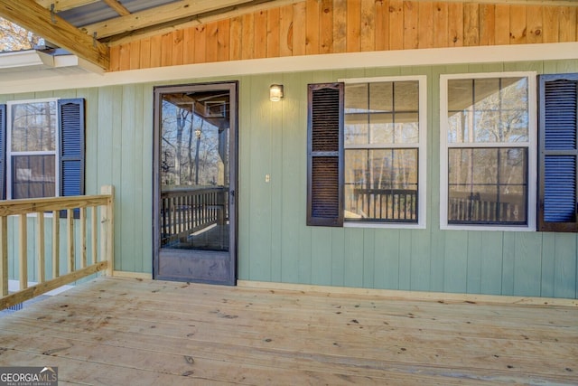 view of exterior entry featuring a wooden deck