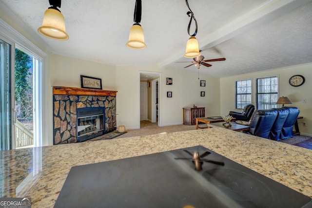 living room featuring beamed ceiling, carpet, a textured ceiling, and a fireplace