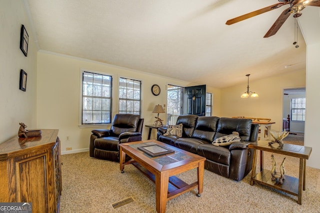 carpeted living room featuring ceiling fan with notable chandelier, lofted ceiling, and crown molding