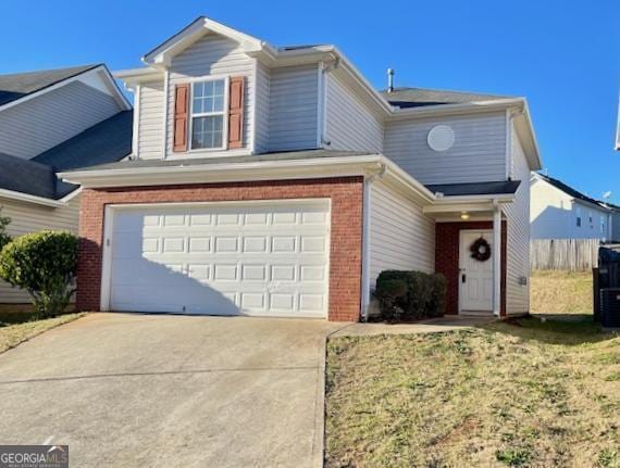 view of property featuring a garage and a front lawn