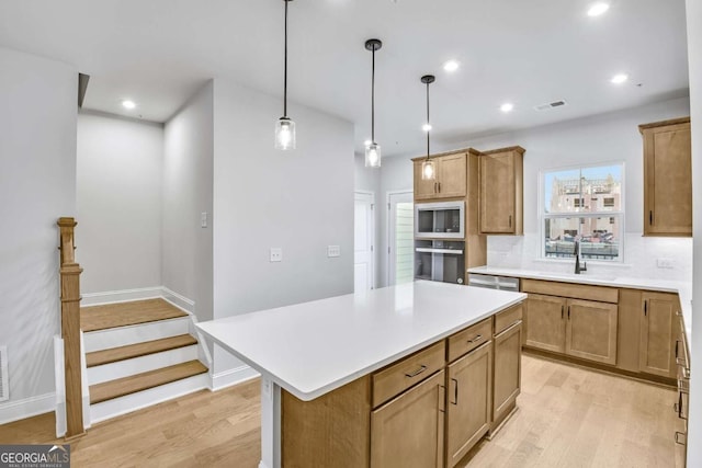 kitchen featuring backsplash, built in microwave, sink, a center island, and oven