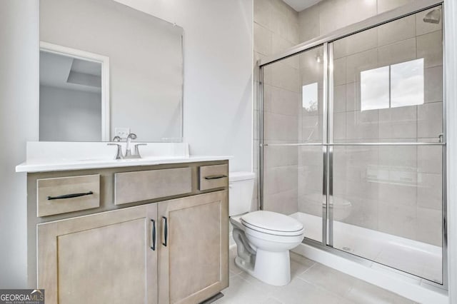 bathroom with tile patterned floors, vanity, an enclosed shower, and toilet