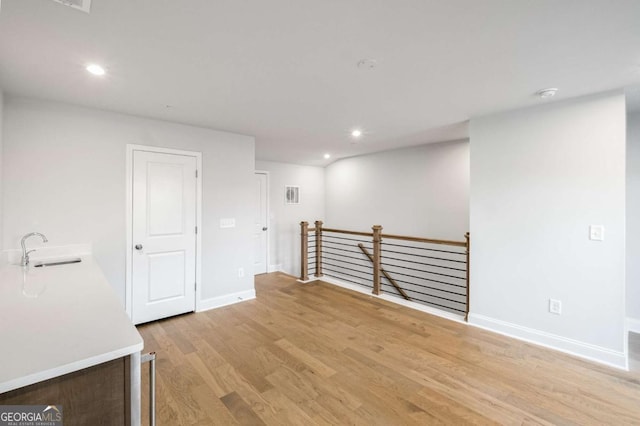 empty room with light wood-type flooring and sink