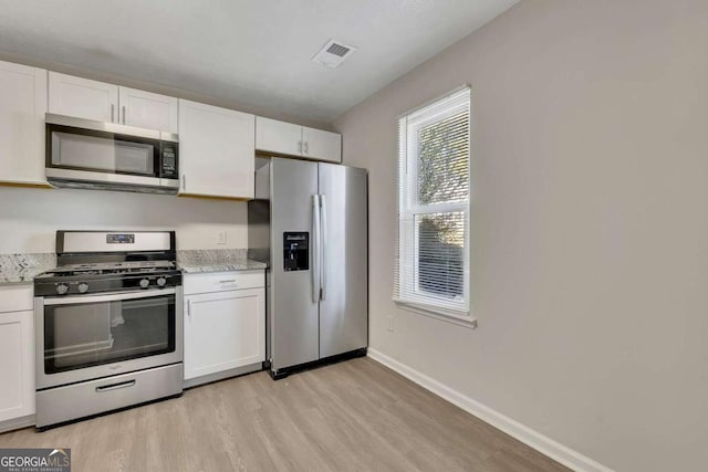 kitchen featuring white cabinets, appliances with stainless steel finishes, and light hardwood / wood-style flooring