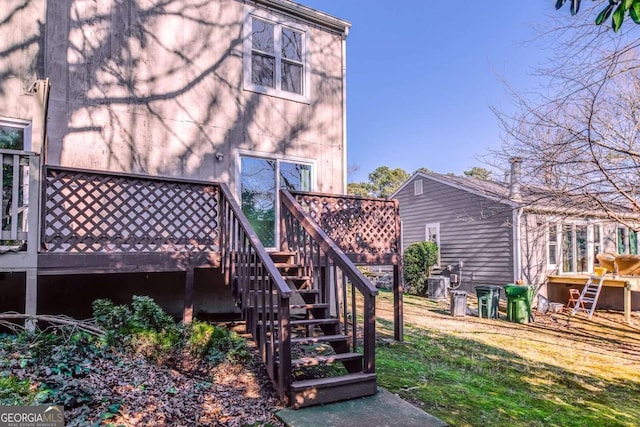 rear view of house with a lawn and a wooden deck