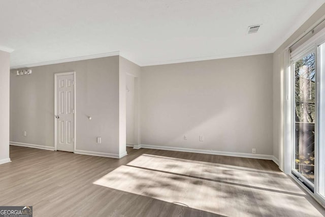 spare room featuring wood-type flooring and ornamental molding