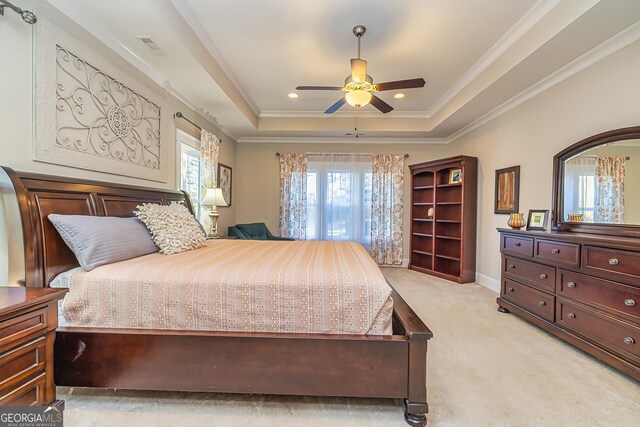 carpeted bedroom featuring a raised ceiling, ceiling fan, and ornamental molding