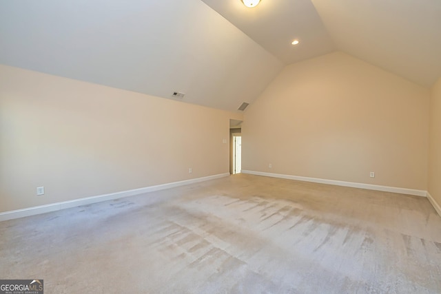 additional living space featuring light colored carpet and lofted ceiling