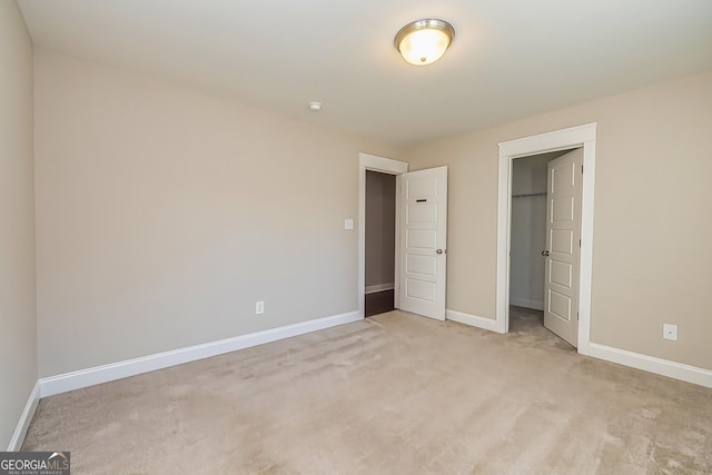 unfurnished bedroom with light carpet and a closet