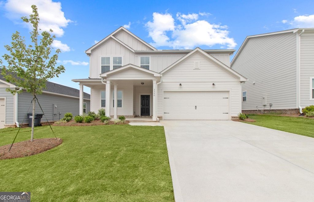 view of front of home with a garage, a front yard, board and batten siding, driveway, and a porch