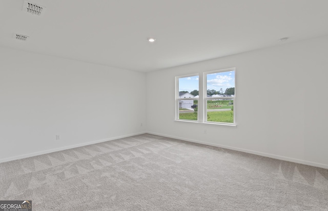 unfurnished room with carpet floors, recessed lighting, visible vents, and baseboards