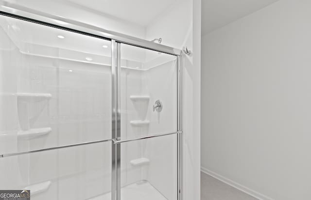 bathroom featuring a stall shower and baseboards