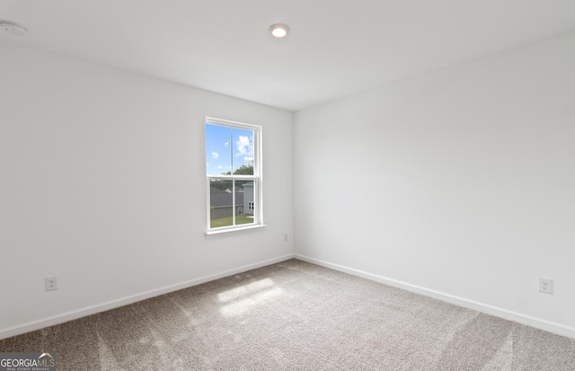 carpeted empty room featuring baseboards