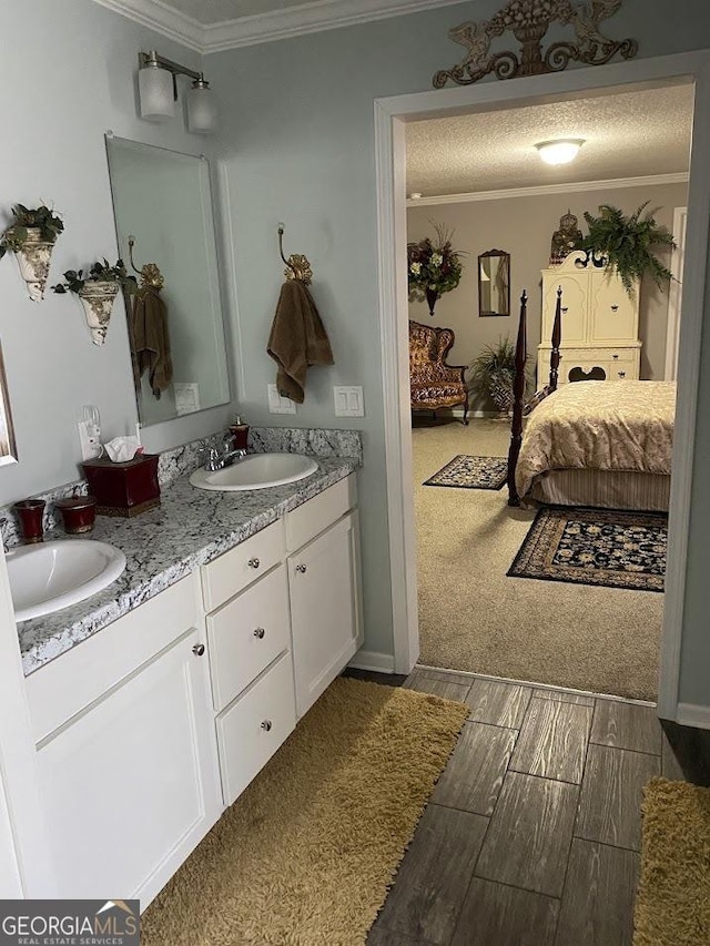 bathroom with crown molding, vanity, and a textured ceiling